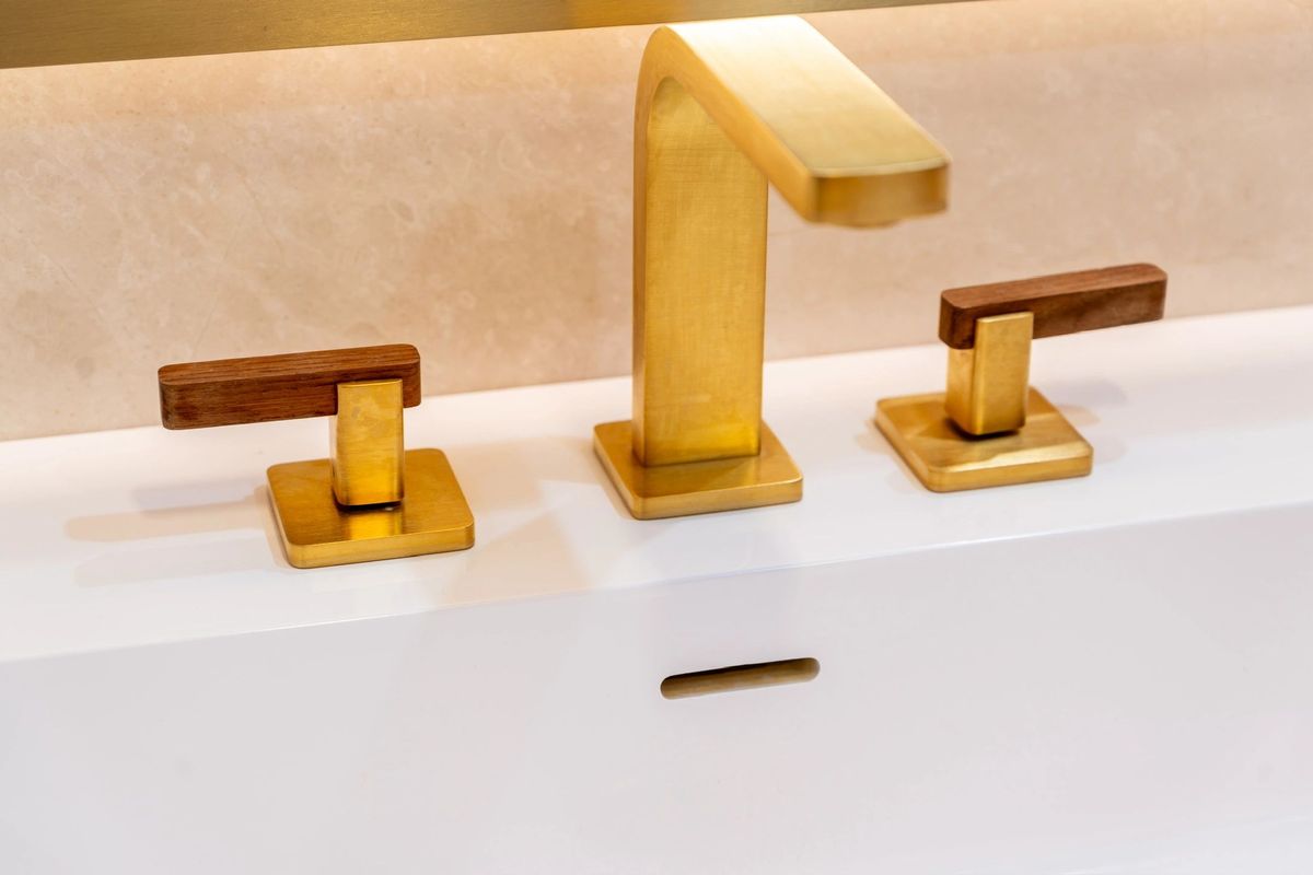 Brushed brass widespread faucet on a solid surface counter